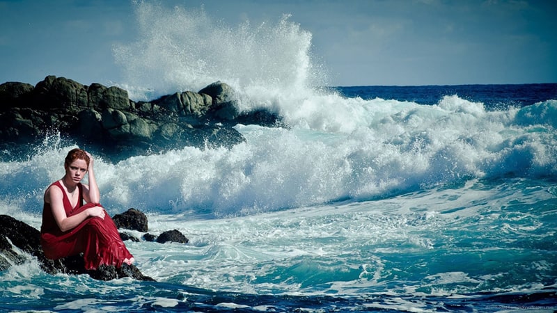 woman-sitting-on-rock-near-body-of-water-thumbnail